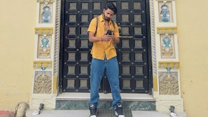 A man standing in front of a hostel named HOTSTEL, which advertises itself as a backpacker hostel. - Mild Life Hostel Udaipur (Udaipur)