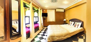 Una camera d'albergo con un letto, uno specchio, una finestra con tende, un pavimento a scacchi e un condizionatore d'aria.