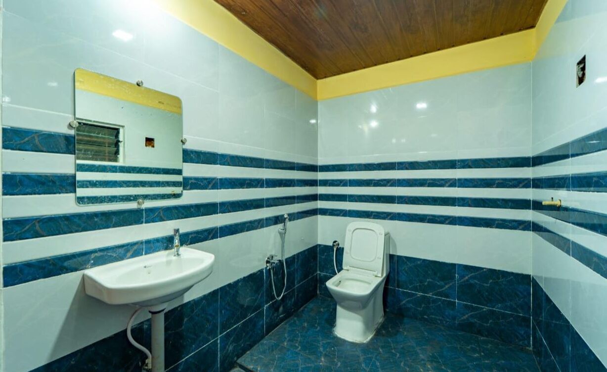 A bathroom with a sink, toilet, and mirror.