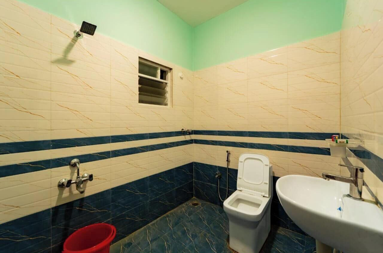 A bathroom with a toilet, bidet, and sink, featuring a striped tile design.