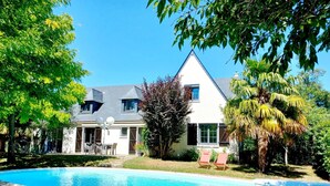 A house with a swimming pool, surrounded by trees and a well-maintained lawn. - Le Clos Beauséjour (Mauges-sur-Loire)