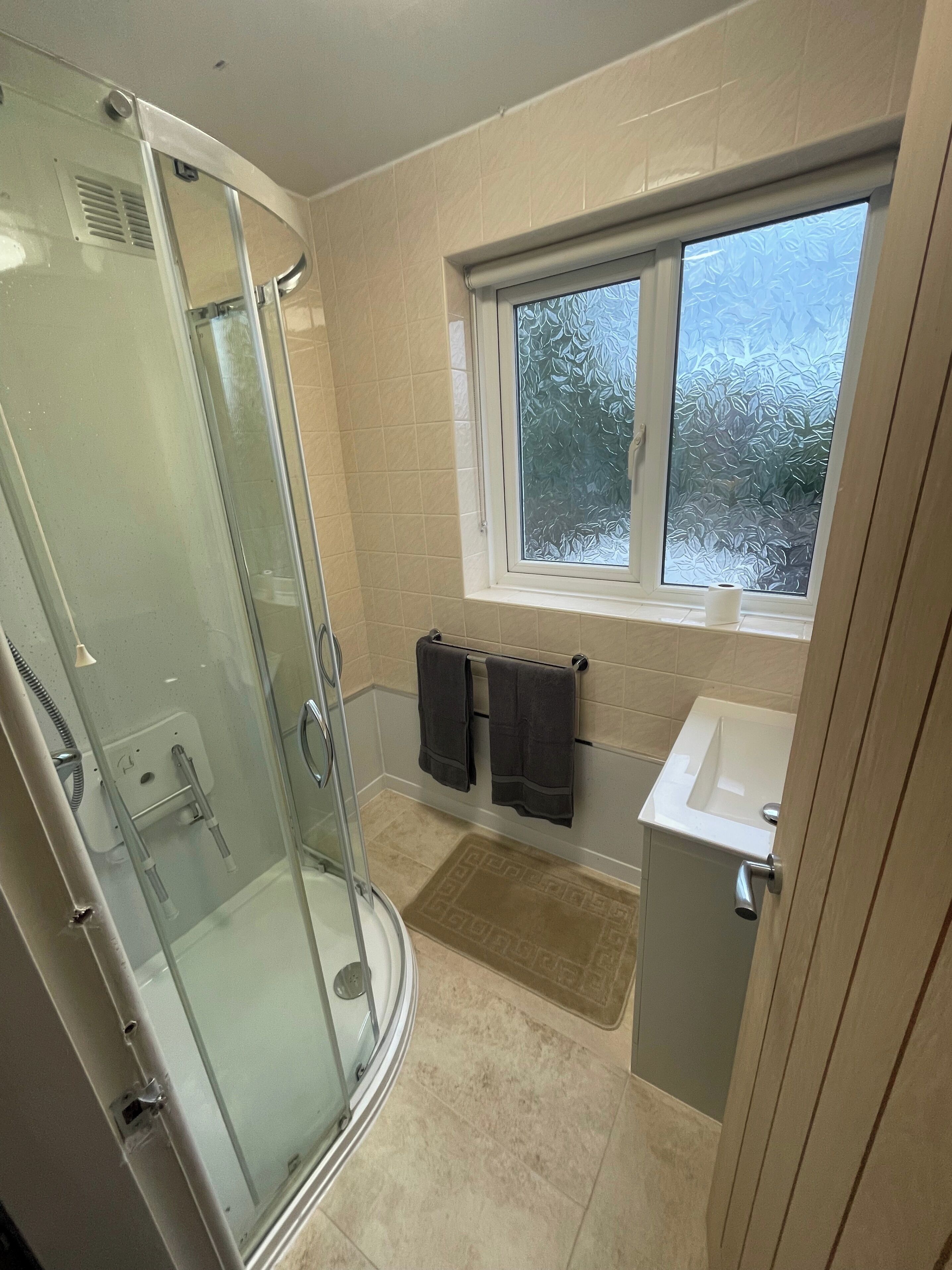 Huis | Badkamer | Een douche, een haardroger, handdoeken