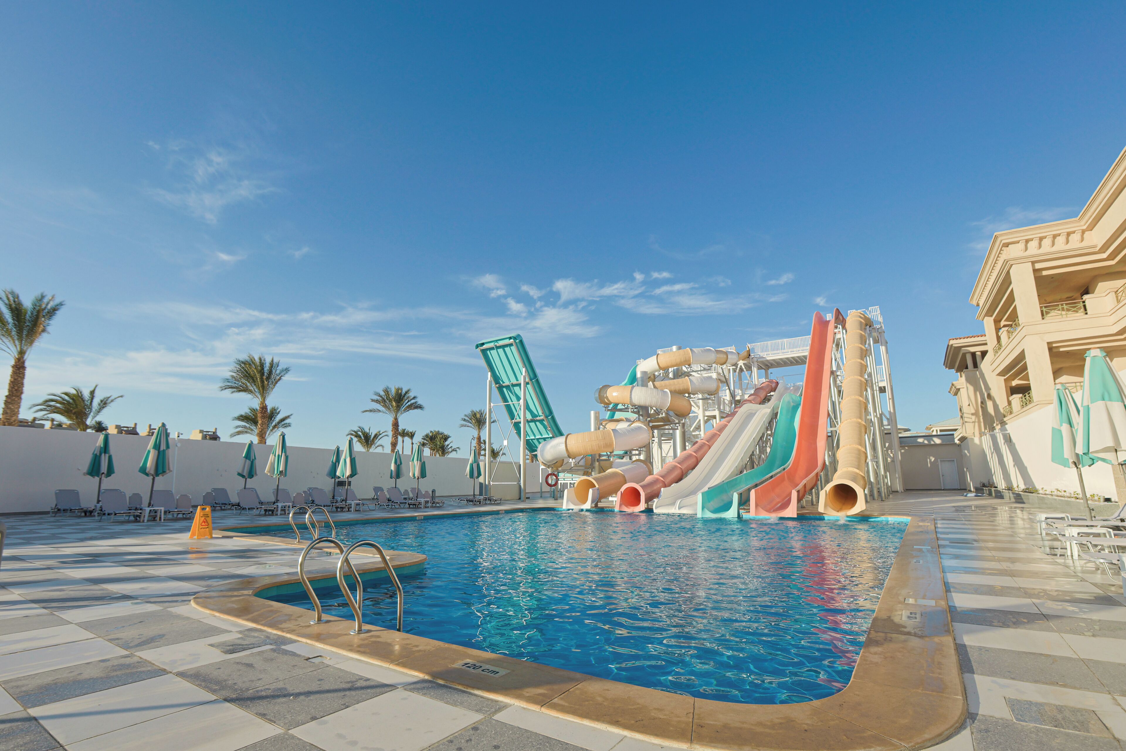 A swimming pool with water slides and lounge chairs.