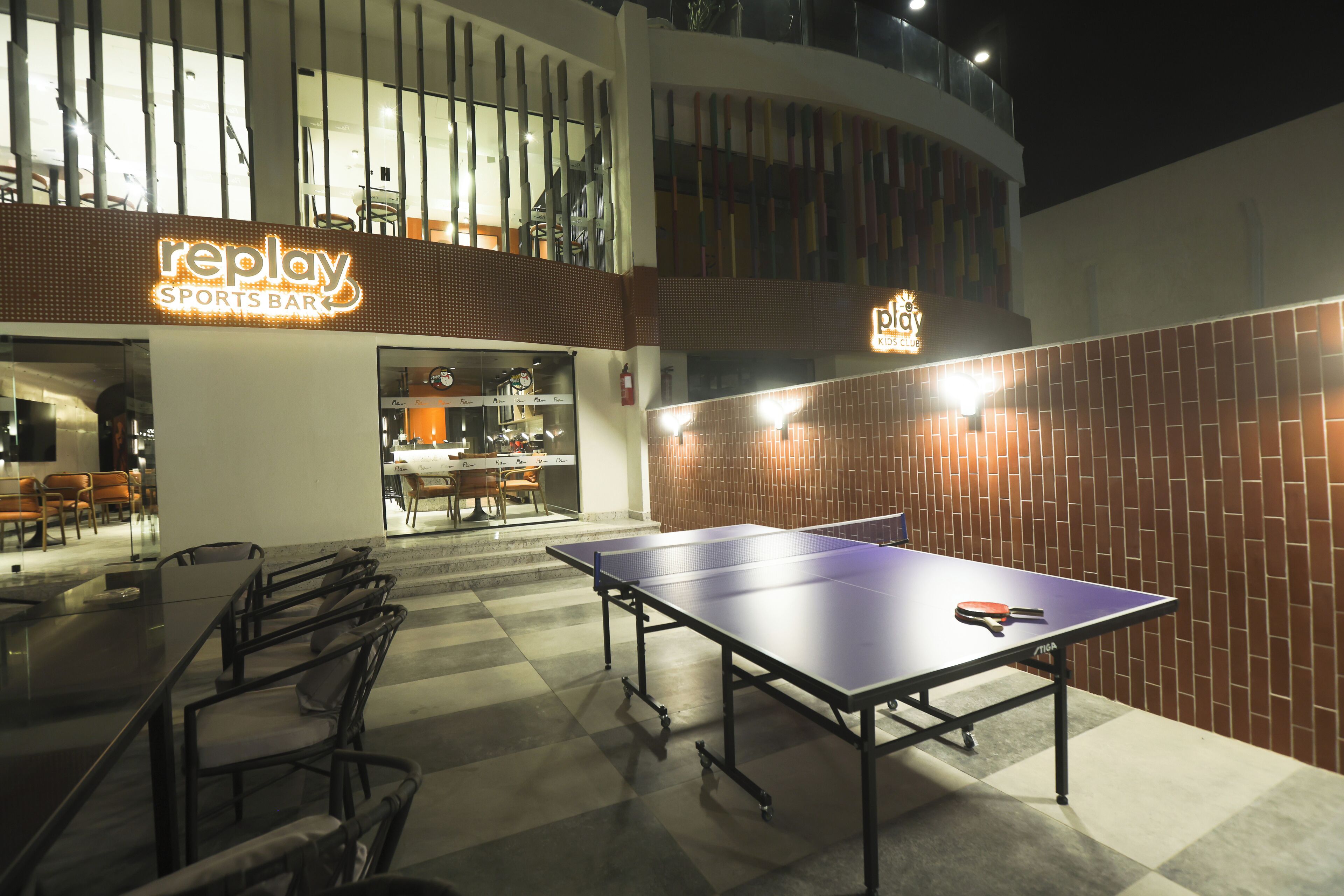 Un bar sportif intérieur avec des tables de ping-pong et des places assises.