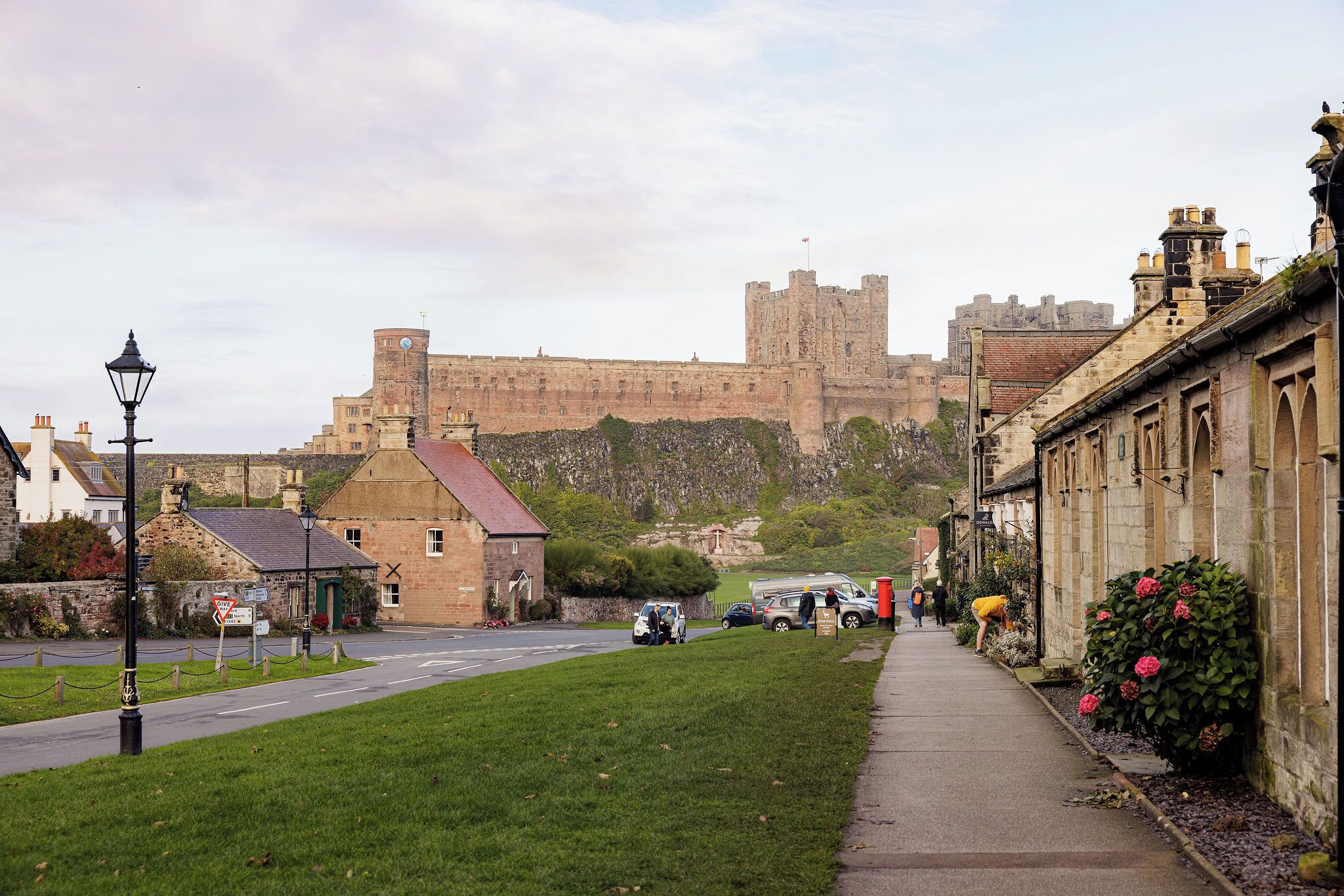 A historic town with a prominent castle in the background, narrow streets, and traditional stone buildings.
