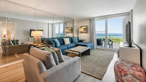 En moderne stue med sofa, sofabord og fjernsyn.