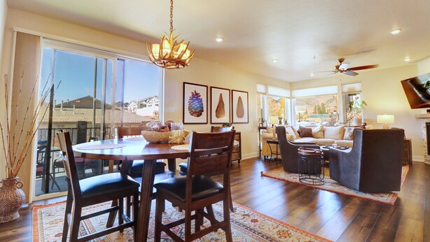 A spacious living area with a large dining table, comfortable seating, and a fireplace. - Sail Lofts 101 2 Bedroom Condo (Dillon)