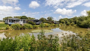 A lakeside property with a house, a covered area, and a small boat dock.