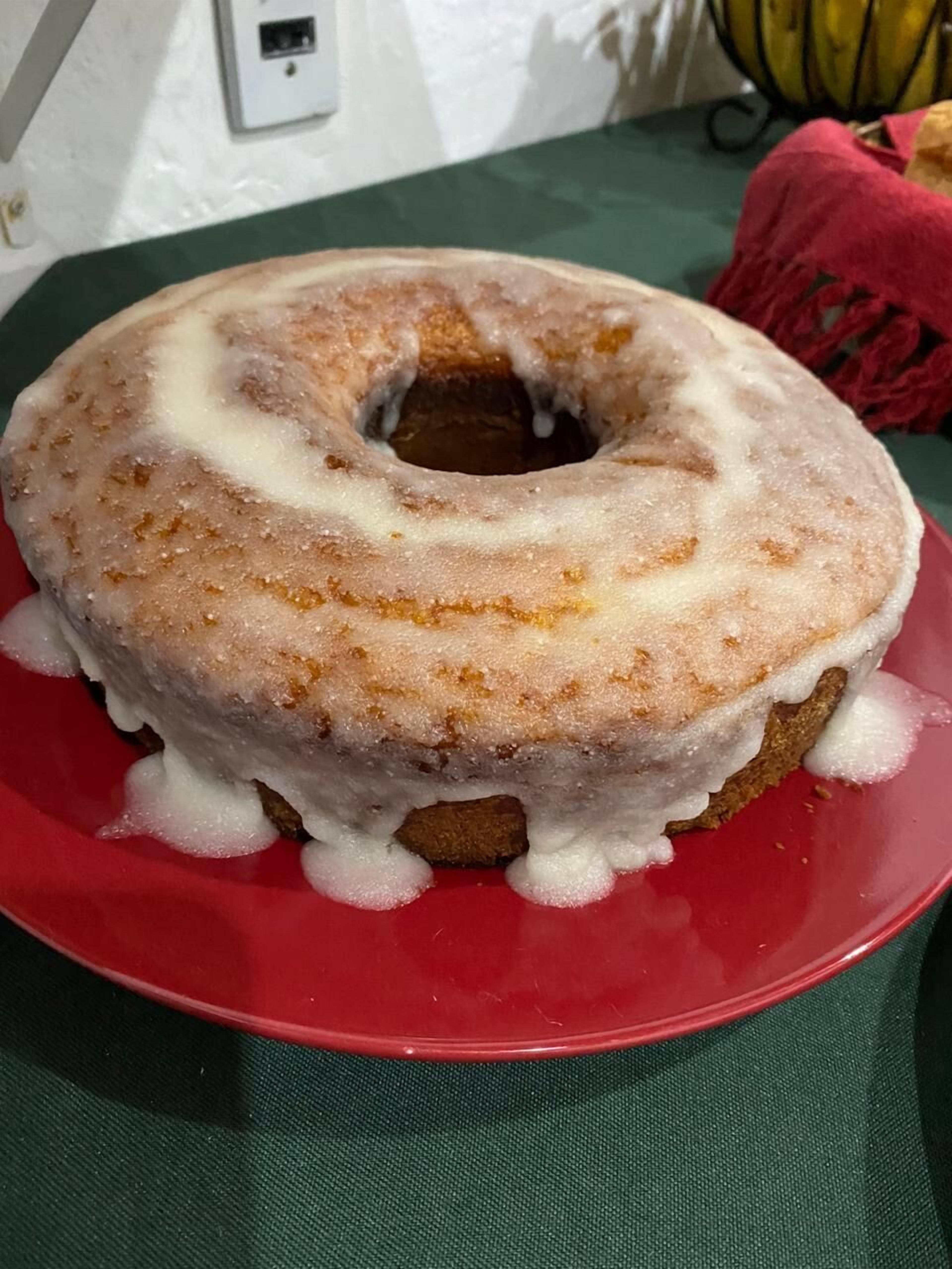 A glazed donut on a red plate.