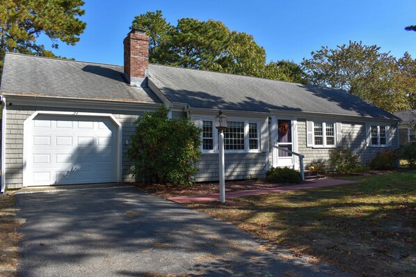 A single-story house with a garage, a brick chimney, and a front porch. - Three bedroom central air in South Yarmouth (South Yarmouth)