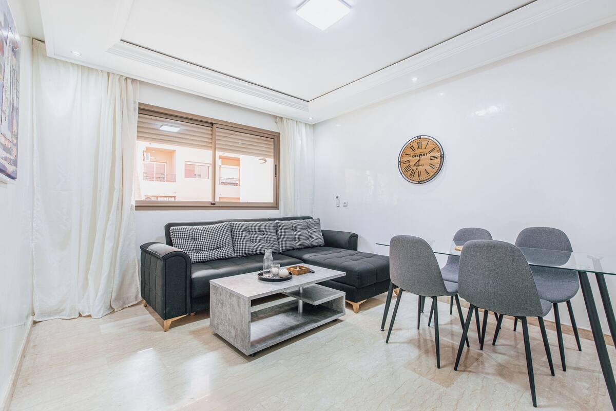 Un salon moderne avec un canapé, une table basse et un coin repas.