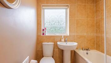 Huis | Badkamer | Een bad/douchecombinatie, een diep bad, een haardroger, handdoeken