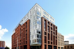 A modern building with a corner entrance, large windows, and a sign reading "The Courtrooms". - Student Only The Courtrooms (Bristol)
