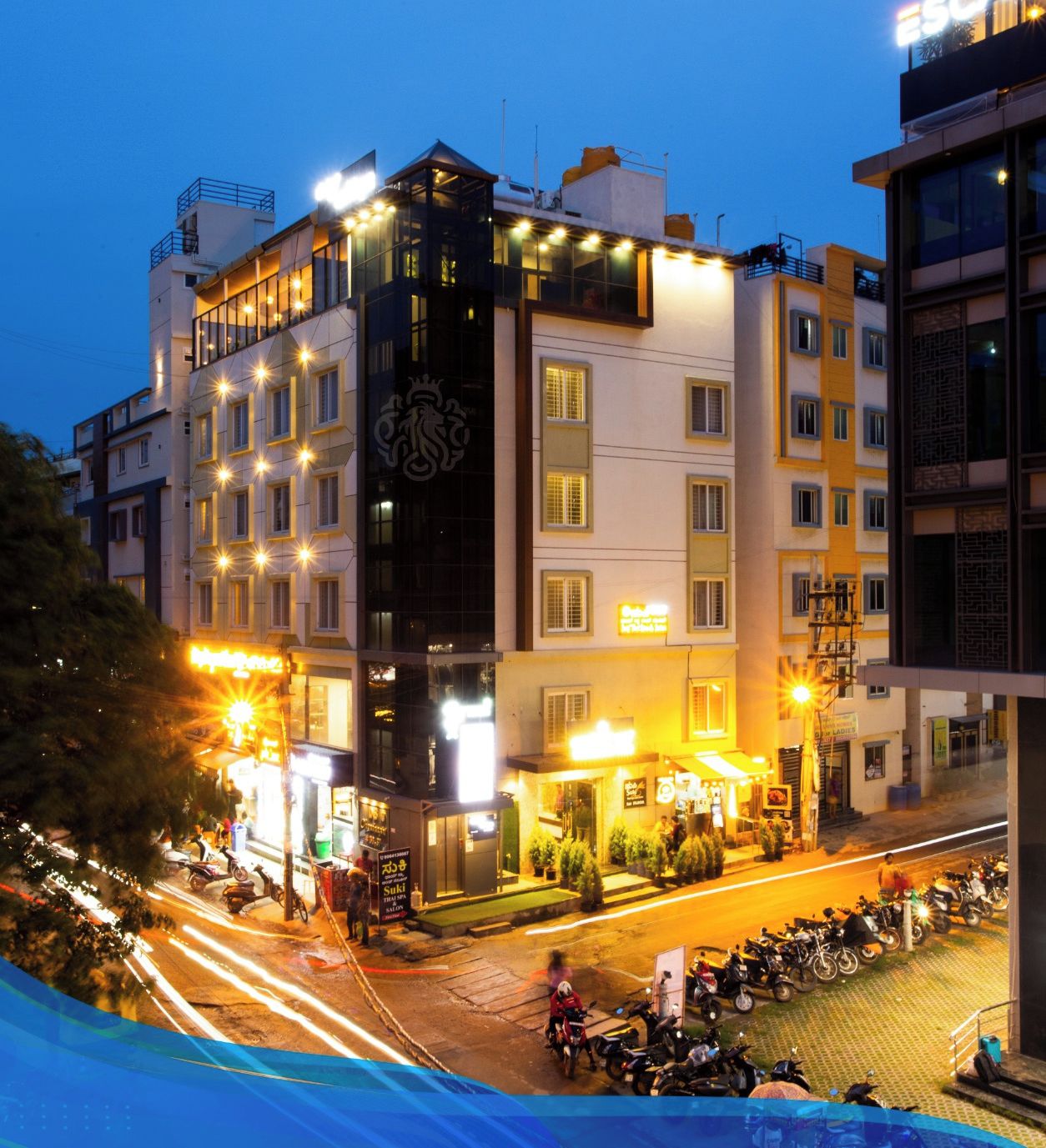 A multi-story hotel with illuminated signage and a prominent emblem on the facade.