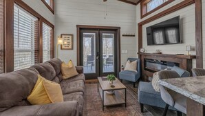 A cozy living room with a brown sofa, a coffee table, and a fireplace.