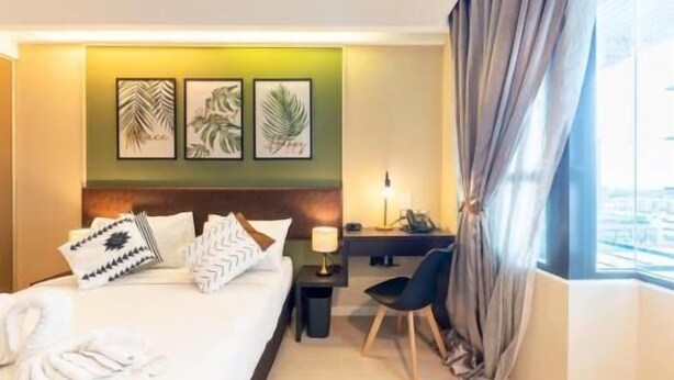 A hotel room with a bed, desk, chair, and curtains. - Master House Centrestage PJ (Petaling Jaya)