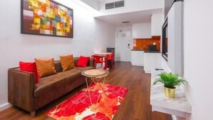 A modern living room with a sofa, a coffee table, and a red rug. - Master House Centrestage PJ (Petaling Jaya)