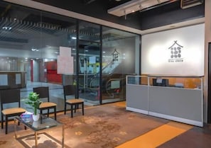 A reception area with a glass wall, a reception desk, and seating. - Master House Centrestage PJ (Petaling Jaya)