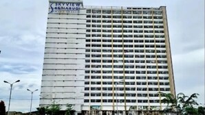 Un grand hôtel à plusieurs étages, doté d’une façade à fenêtres disposées en réseau et d’une enseigne indiquant « SKYVIEW SHABUDI ».