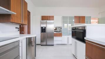 Vila com design assinado, vista para a montanha | Cozinha privada | Geladeira grande, micro-ondas, fogão, cooktop