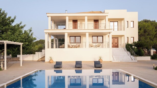 Un bâtiment à deux étages avec une piscine devant.