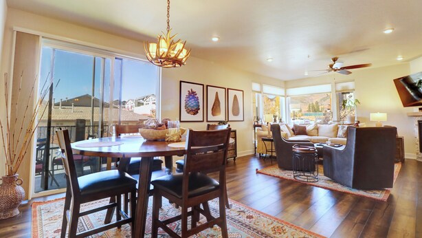 A spacious living area with a dining table, chairs, and a sofa. There is a chandelier hanging from the ceiling and a fireplace in the background. - Incredible Remodeled Luxury Condo (Dillon)