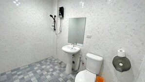 A bathroom with a white sink, toilet, and shower. - Little Seoul (Chiang Mai)