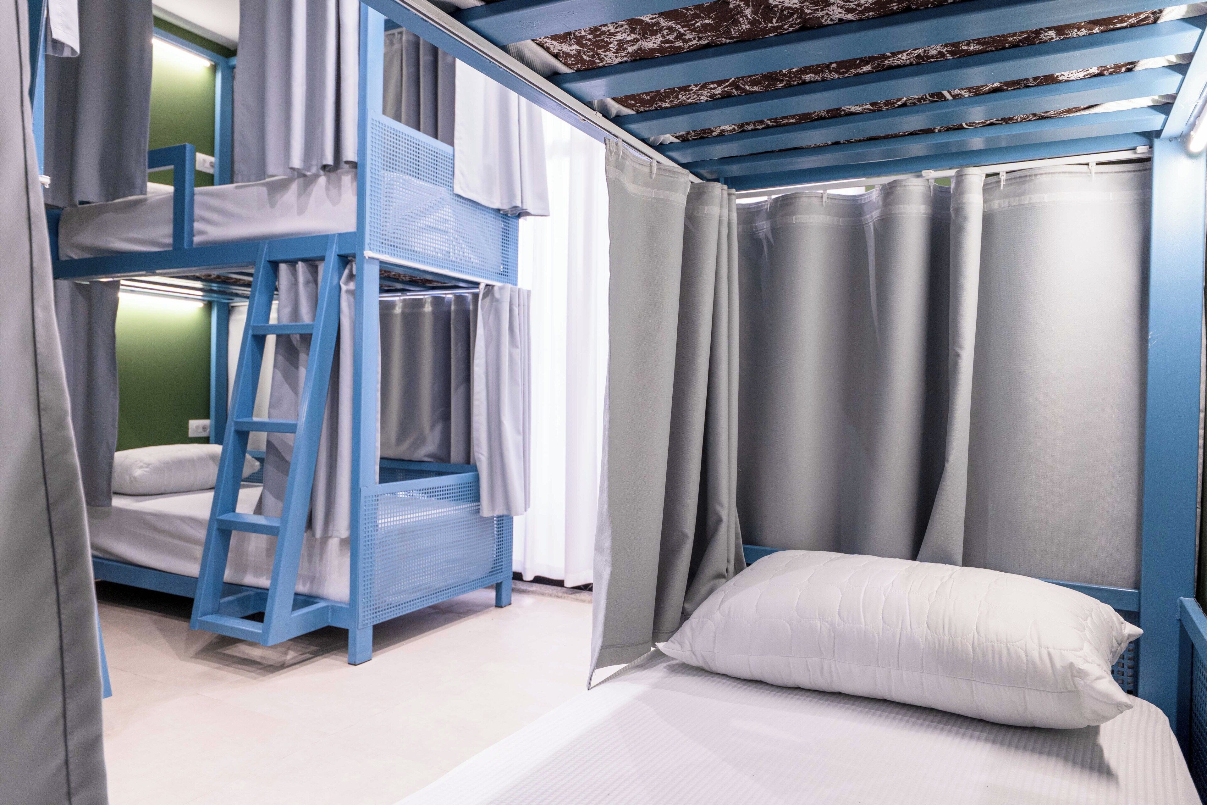 Habitación con literas, una cama individual y cortinas.