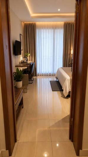 A hotel room with a bed, desk, chair, potted plant, and a TV. - Remarkable 3-bed House in Kigali (Kigali)