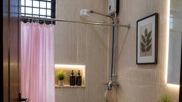 Un baño con inodoro, bidé, lavamanos, ducha y una cortina rosa.