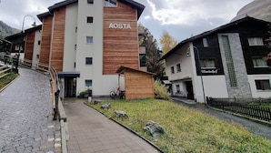A modern building with a sign reading "AOSTA" and another sign "Maranhof" on a neighboring building. - Studio Aosta (Zermatt)