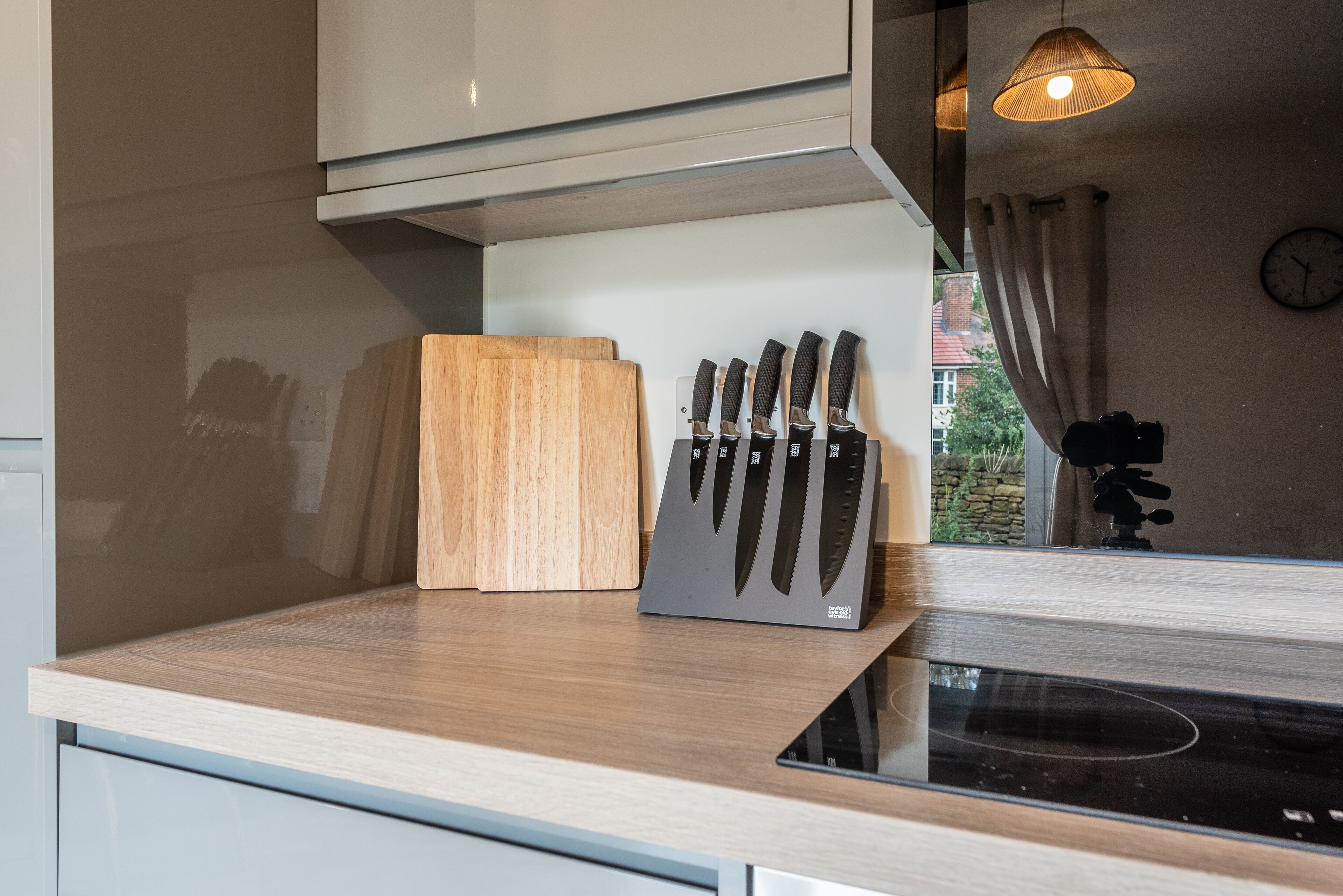 A kitchen with a wooden cutting board, a knife block, and a modern stove.