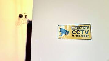 A door with a warning sign indicating CCTV is in operation.