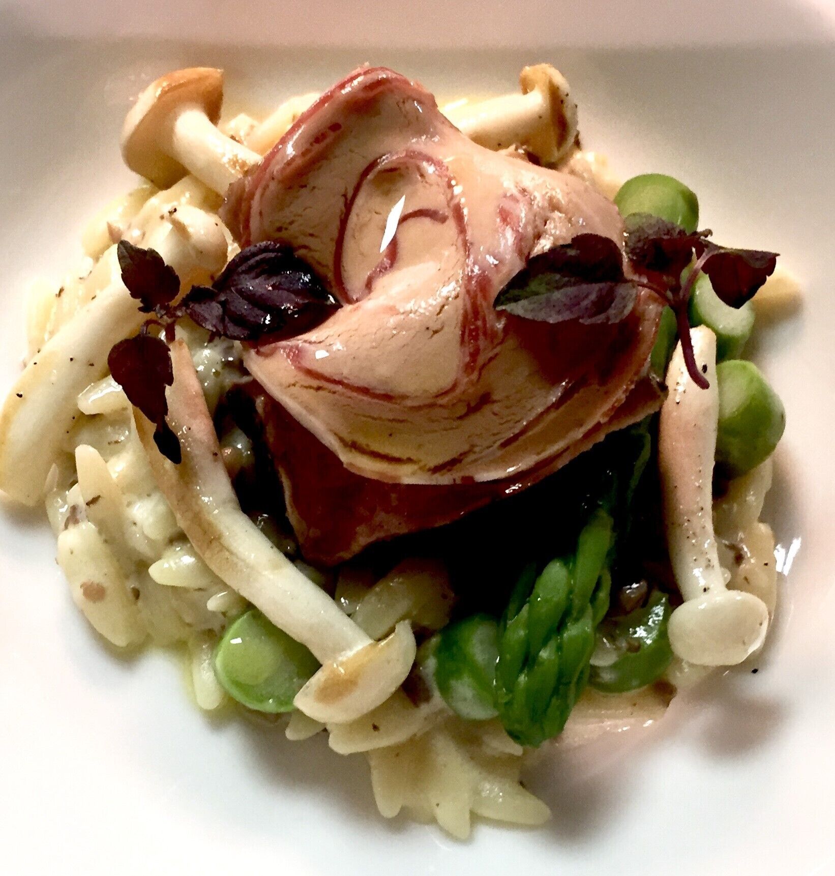 En tallrik med mat bestående av pasta, gröna grönsaker och en bit kött.