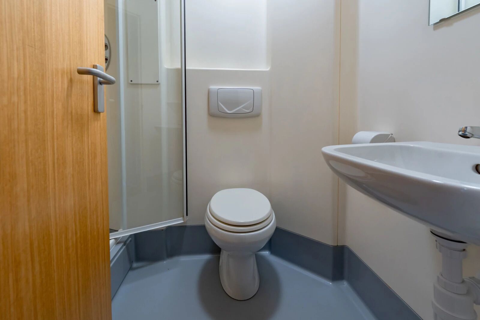 Un baño con inodoro, lavabo y ducha.