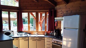 Una cocina compacta con armarios de madera, un lavamanos, una estufa y un refrigerador.