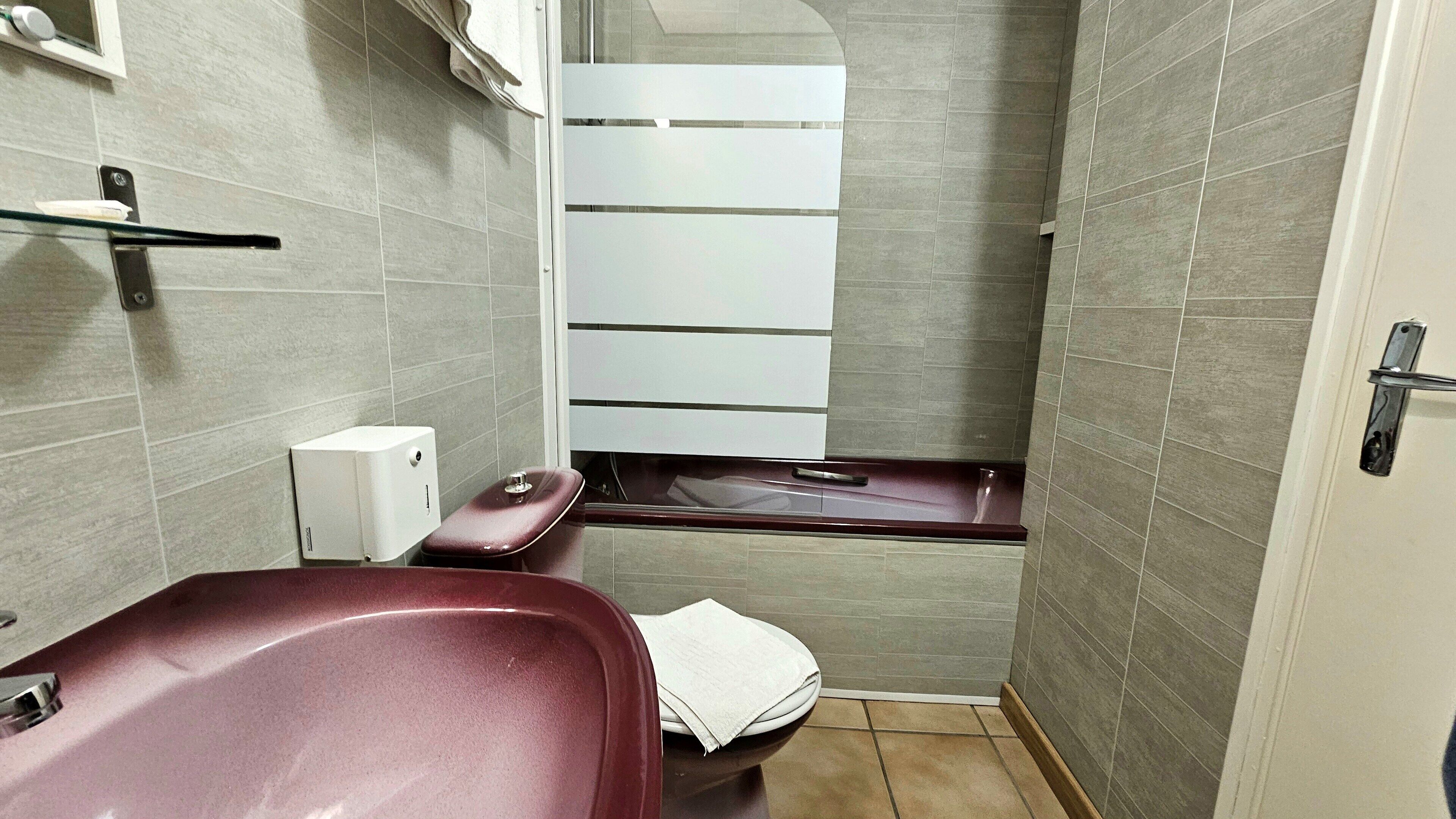 A small, modern bathroom with a sink, toilet, and a mirror.