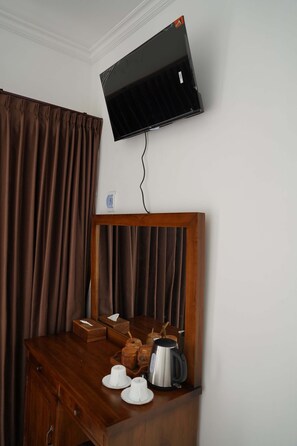 Relax in this inviting room with a dresser, flat-screen TV, and electric kettle.