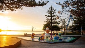 Un parco acquatico con una ruota panoramica e giochi gonfiabili.