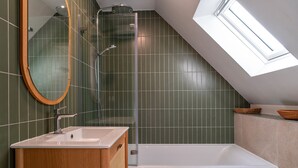 Un bagno moderno con un lucernario, una doccia e una vasca da bagno.
