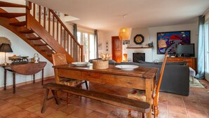 Un accogliente soggiorno con un tavolo da pranzo in legno, una panca e una scala.