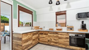A modern kitchen with wooden cabinetry, a built-in oven, and a microwave.