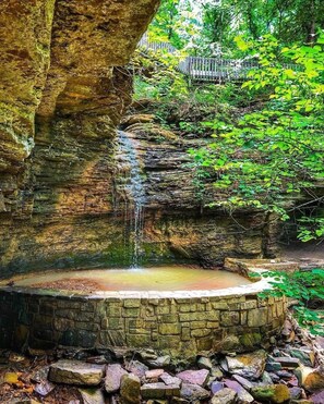 A natural rock formation with a small waterfall and a circular stone pool. - Grandmas FarmHouse 3bd n Poteau OK. Charming & Quiet, mins to everything  (Poteau)