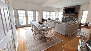 A spacious living area with a dining table, sofa, and a stone fireplace.