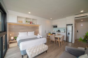 A modern hotel room with a large bed, a small desk, a kitchenette, and a seating area. - Apartment in the gastronomic zone, San José, Barrio Escalante (San José, Carmen)