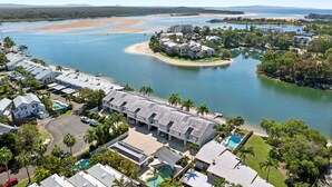 A coastal residential area with houses, a swimming pool, and a beach.