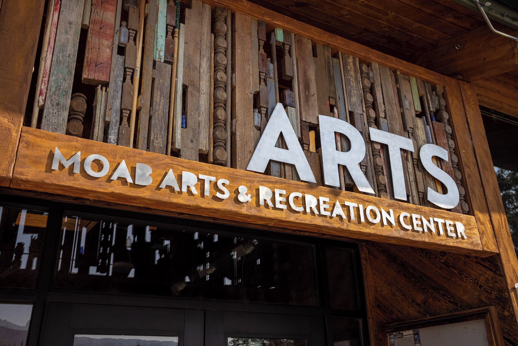 Een houten bord met de tekst 'ARTS & RECREATION CENTER', dat wijst op een locatie voor kunst en recreatie.