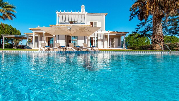 Un grand bâtiment blanc avec une piscine devant.