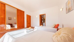 Une chambre d’hôtel avec deux lits, un grand miroir et une armoire en bois.