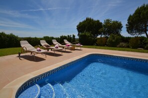 Ein Pool mit Liegestühlen und einer Fliesenbordur.